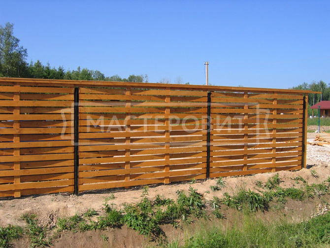Плетеный забор из дерева с металлическими столбами